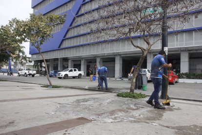 Trabajadores de una empresa de limpieza ayer removían las manchas de sangre que aún quedaban en la vereda.