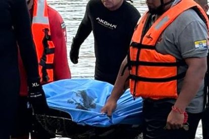 Los rescatistas sacan el cuerpo de Benjamín Caiza, quien cayó al río Daule.