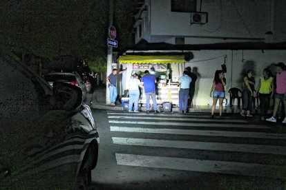 Una carreta usa la luz de una camioneta para alumbrar a sus clientes.