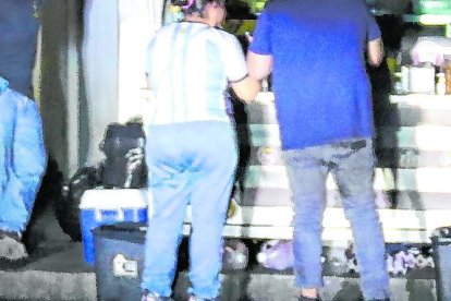 Una carreta usa la luz de una camioneta para alumbrar a sus clientes.