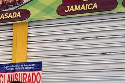 Funcionarios de Arcsa colocando la calcomanía de clausurado en uno de los cinco restaurantes