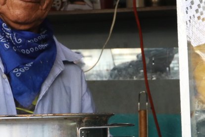 El Chino agita el caldo en la olla antes de despachar un encebollado.
