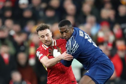 Wllian Pacho (d) en la marca sobre un jugador de Liverpool, en el partido de PSG en Anfield, por los octavos de final de Champions League