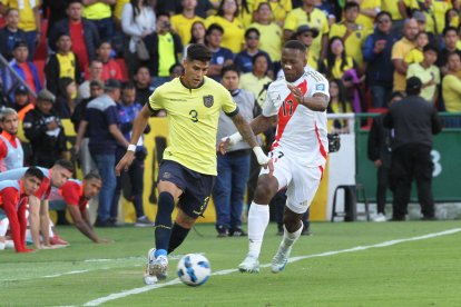 Piero Hincapié (i), defensa de Ecuador, disputa una pelota con Luis Advíncula, lateral de Perú.
