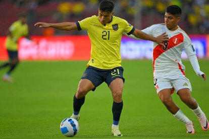Alan Franco y Piero Quispe luchan durante el partido de las eliminatorias sudamericanas entre Ecuador y Perú en el estadio Rodrigo Paz Delgado de Quito.