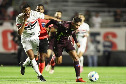 Sabino (i) de Sao Paulo disputa el balón con Lisandro Alzugaray de LDU, en un partido de cuartos de final de la Copa Libertadores.