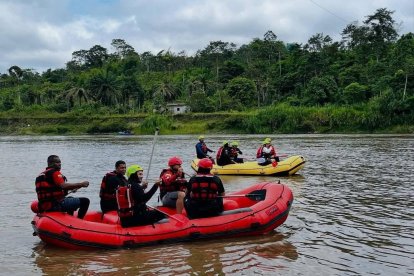 Rescatistas del Cuerpo de Bomberos de Quinindé realizan labores de búsqueda en el río Blanco, apoyados con botes inflables y equipos de seguridad.