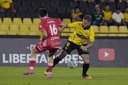 Darío Benedetto (d) delantero del Barcelona SC, en acción ante Argentinos Juniors.