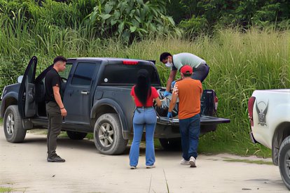 Agentes y moradores colaboran en el levantamiento del cuerpo hallado en la playa del recinto África, en medio de la conmoción que generó el hallazgo.