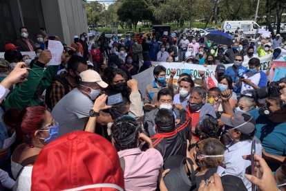 A la izquierda del alcalde Yunda está un hombre que no usa correctamente la mascarilla.