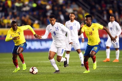 Jefferson Orejuela (18) disputa la pelota con el delantero de Honduras, Anthony Lozano (9).