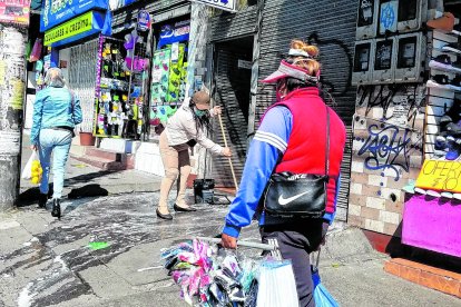 Rocío Cuacer limpia la entrada de su local.
