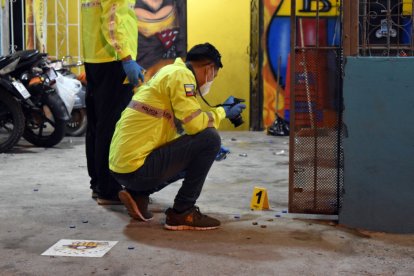 Agentes de Criminalística analizan los indicios encontrados en el sitio del ataque.