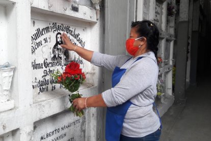Antes de irse a su casa, María del Rosario deja sus ramitos en varias bóvedas.