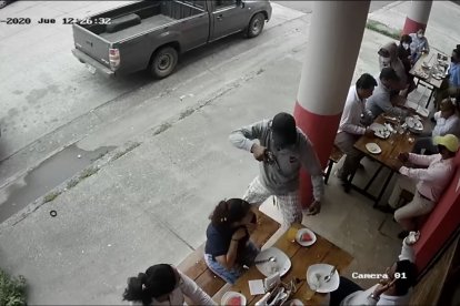 En la grabación se observa a uno de los sujetos apuntando a los clientes con un arma de fuego.