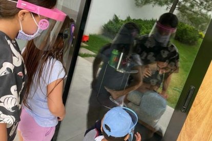 El delantero Ángel Mena saluda a su familia, a través de una puerta de vidrio, para evitar contagiarlos de Covid-19.