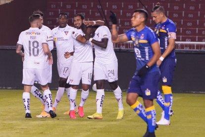 Moisés Corozo (c) es felicitado por sus compañeros de Liga de Quito tras marcar el gol con un potente tiro libre.