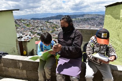 María Iza cuida de sus nietos mientras su hija trabaja. Ella pide el internet a una vecina para que accedan a sus clases.