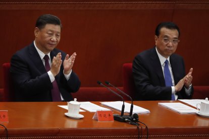 El presidente chino Xi Jinping (izq.) Y el premier chino Li Keqiang (der.) Aplauden durante una reunión elogiando modelos a seguir en la lucha del país contra la epidemia de COVID-19 en el Gran Salón del Pueblo (GHOP) en Beijing.