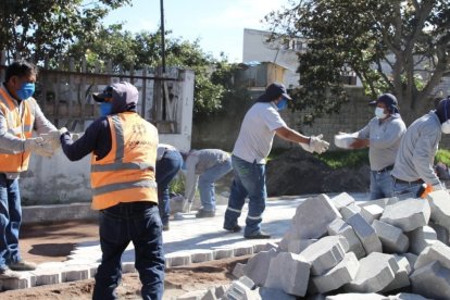 Una cuadrilla de obreros adoquinan los pasajes del barrio La Carolina