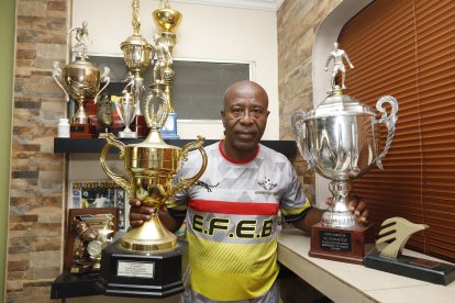 Ermen Benítez sostiene un par de trofeos, de los más de 200 que asegura haber ganado en su época de jugador.