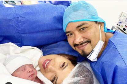 Los felices padres junto a su bebé.