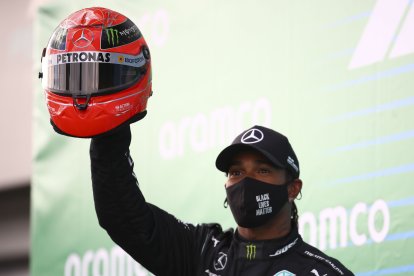 Lewis Hamilton celebra su triunfo número 91 con el casco de Michael Schumacher que recibió de parte de sus hijo Mick.