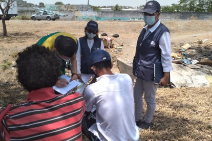 Funcionarios del MIES dialogan con dos personas que viven en las calles.