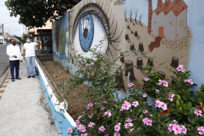 Raúl Campoverde y Víctor Albán observan uno de los murales pintado en una esquina de la calle 44, suburbio de Guayaquil.