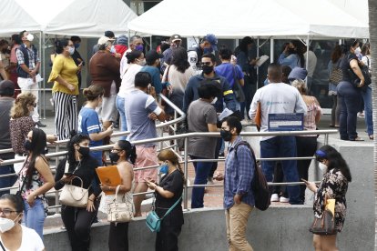 En una extensa fila, usuarios del SRI esperan el turno sin cumplir el distanciamiento.