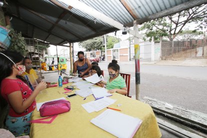 Laura Alvarado (blusa amarilla) ayuda a sus sobrinas en las tareas. Ella vive al frente del cementerio de Pascuales. 
Agencia (ag-extra)