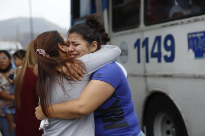 La esposa del policía fallecido recibe el consuelo de sus seres queridos.