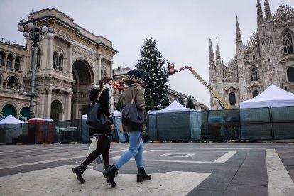 Italianos transitan cerca de un árbol de Navidad en Milán.