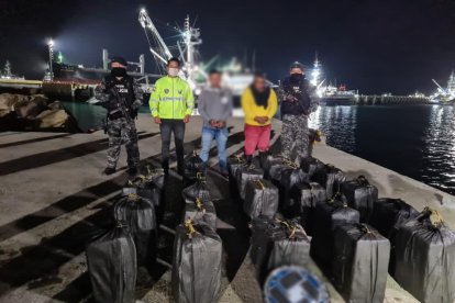 Los dos detenidos y la droga aparecen junto a agentes antinarcóticos.