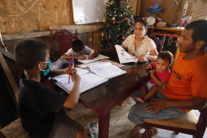 En la cooperativa Balerio Estacio, al noroeste de Guayaquil, un par de niños intentan igualarse en las tareas.