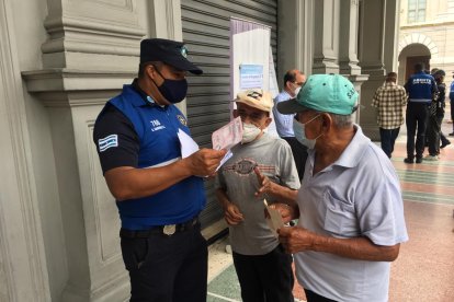 Dos adultos mayores eran orientados por un guardia municipal esta mañana.