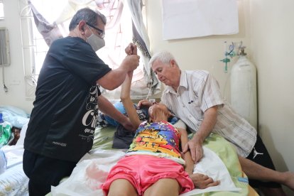 Edilber (izq.) antes de tratar a su paciente pone en manos de Dios la terapia. Don Ulpiano al pie del cañón, siempre junto a su ‘ñora’.