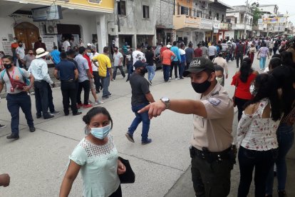 Un policía trata de poner orden en la calle llena de votantes.