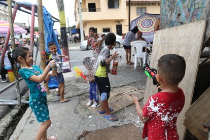 En las calles 31 y Brasil, los niños disfrutan del carnaval jugando con espumas y pistolas de agua.