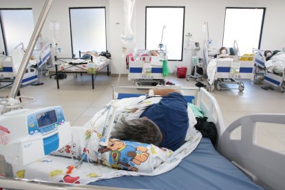 En este lugar antes funcionaba una cafetería. Ahora se atiende a pacientes leves. Muchos de ellos permanecen acostados.