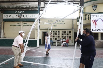 Socios. dirigentes y particulares colaboran para mantener listo el escenario para la jornada que se desarrolla hoy en el club del suroeste de Guayaquil.