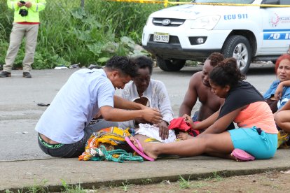 Familiares del joven ahogado lloraban desconsoladamente. Su abuela (blusa blanca) destapaba el cuerpo y lo abrazaba.