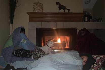 Alexandra trataba de calentarse con su hijo Francisco (12 años) junto a la chimenea de su vivienda.