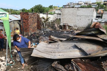 Nancy Álvarez Aguayo busca entre los escombros alguna pertenencia que no haya sido consumida por el fuego.