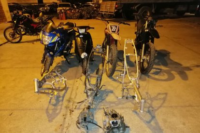 Las motos y repuestos hallados en el taller de reparaciones junto a los sospechosos.