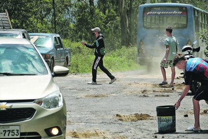 Desde hace varios años la calle OE11 tiene grandes baches y grietas. Los extranjeros aprovechan para ganar dinero.