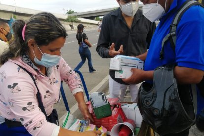 Vendedores informales ofrecen mascarillas y emplasticar el certificado de votación.