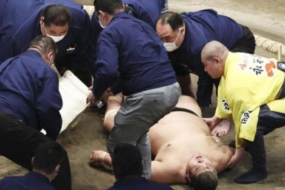 El luchador yace en el piso tras el mortal golpe, mientras tratan de auxiliarlo.