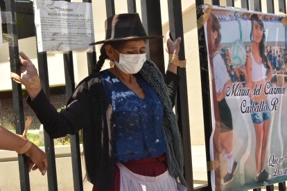 Pilar Reyes, una humilde mujer quechua, protesta atando sus manos con cinta adhesiva a la reja del Tribunal Departamental de Justicia de Cochabamba.