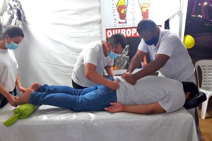 Yulica, Hernando Niño y Édison Hurtado con un paciente en su carpa. El en el fondo se observa parte de la noria del Malecón del Río.